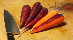 Red carrots and knife on the cutting board.